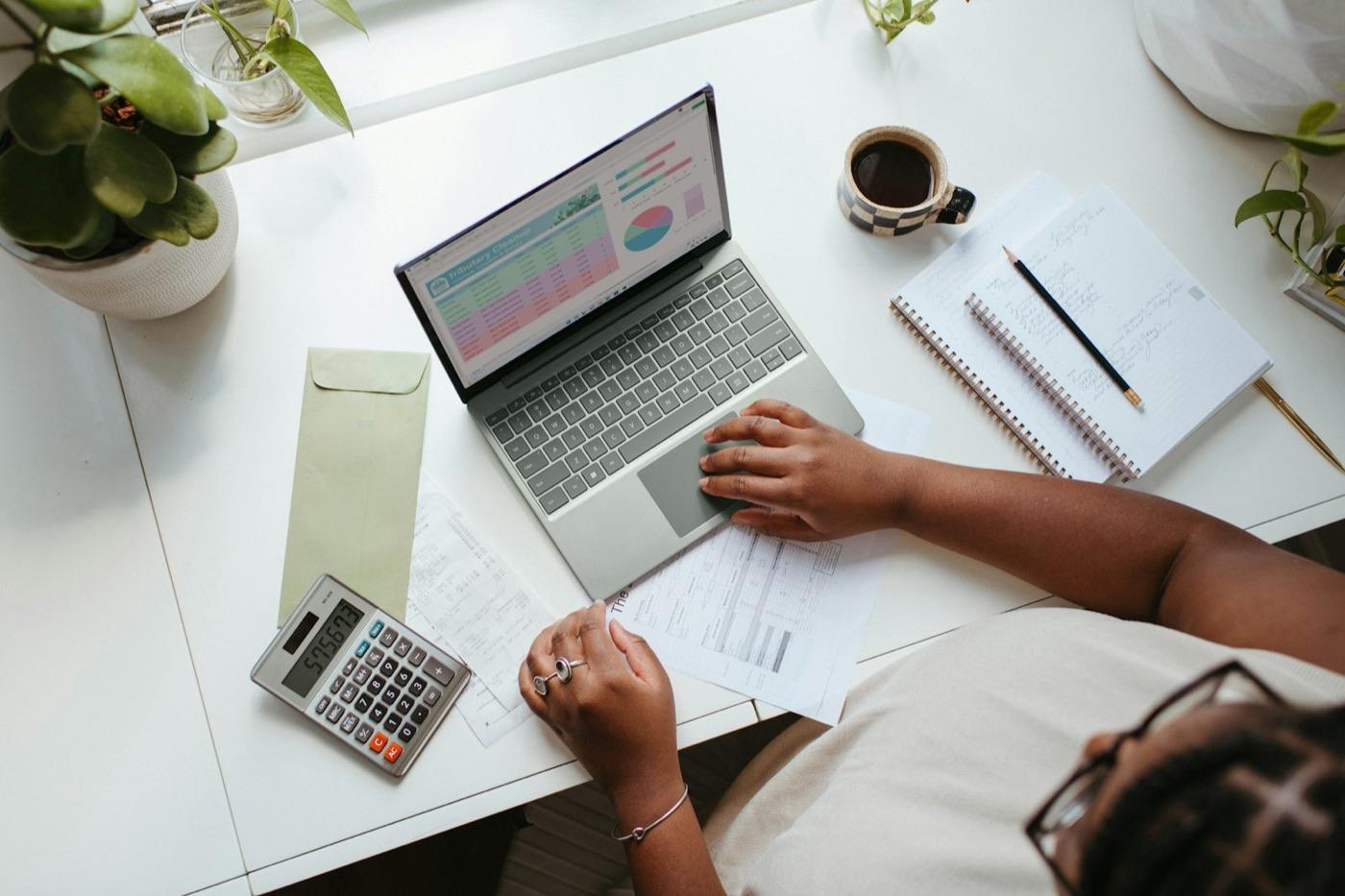 A practice owner working through client paperwork at a laptop